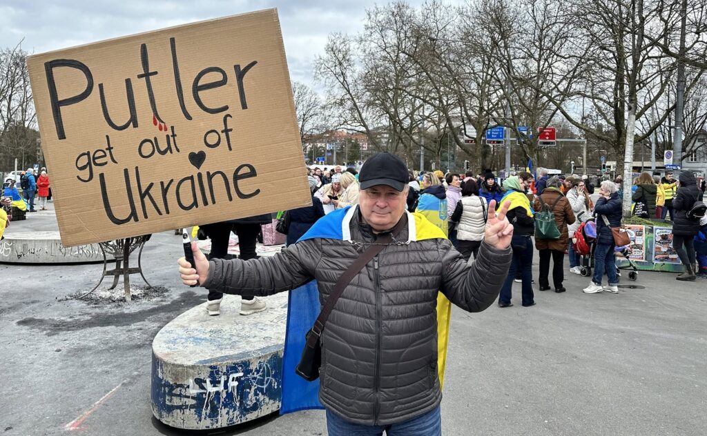 Mykhailo Tits is posing with the placard “Putin, go away from Ukraine” at a meeting in Swiss Bern, February 24, 2024 (a Facebook photo)